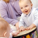 Baby with big smile and floor tom drum